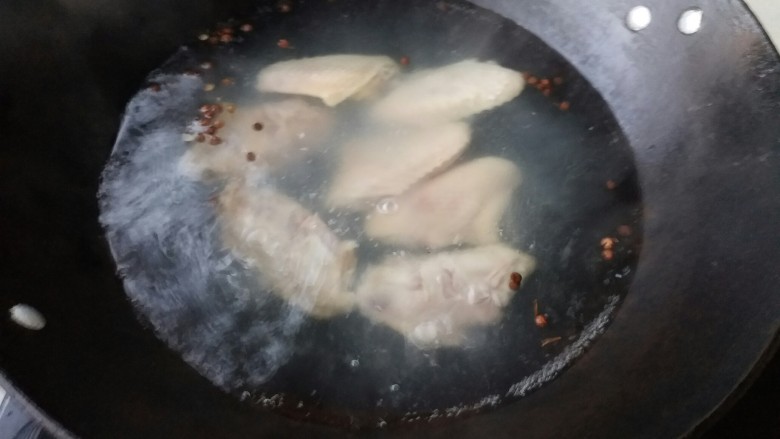 红烧鸡翅莲藕,炒锅坐炉具上倒入清水,放入鸡翅在放入花椒去腥,开水焯3分钟即可捞出