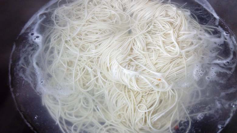秋葵大虾香肠面,煮沸后,加入半碗凉水,中火煮至沸。
