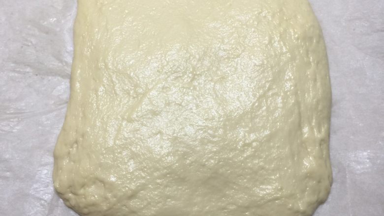 卡仕达奶油面包块,面团排气,底下放上一层硅油纸,按压呈正方形包起来,放入冰箱冷冻30分钟。