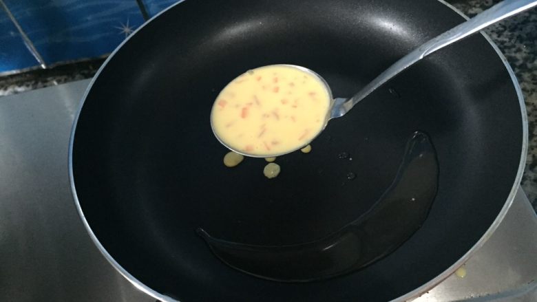 火腿胡萝卜鸡蛋饼,等油热一下后,就用汤勺把准备好的蛋粉糊慢慢的捣在锅上