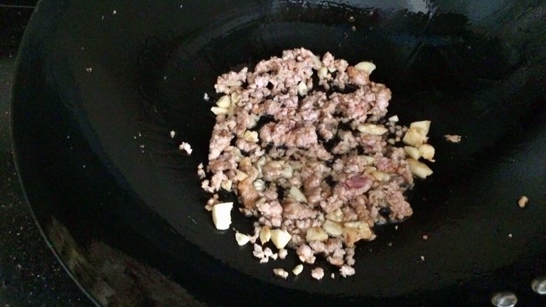 肉末茄子,锅内留少许油,蒜爆香,倒入肉末翻炒。