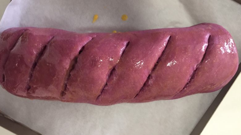 紫薯大列巴,发酵好后165度预热烤箱
在面包上割几道口子,深一点,以见到里面的馅为准
我用的刀不好,这回割不好…
擦点蛋液在表面