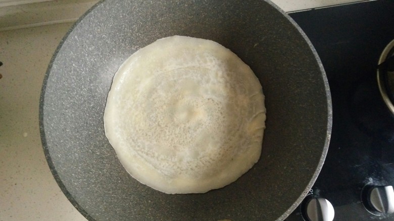 鸡蛋软饼,饼四周微微翻起时将饼翻面煎,四周淋少许油晃动饼子使油均匀,约煎20秒。
