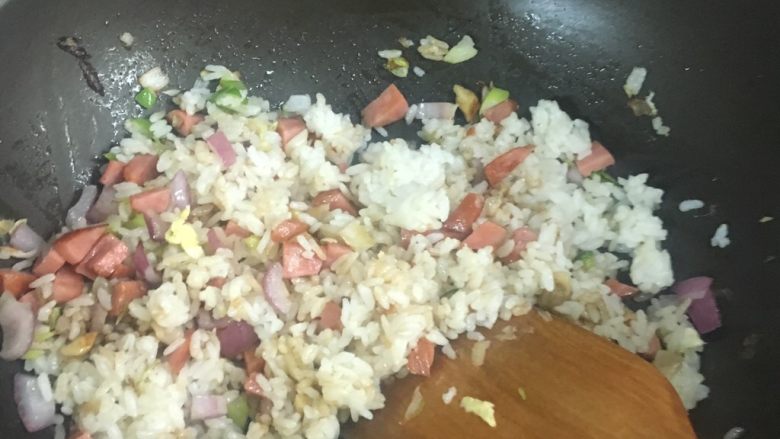 炒饭秀家常炒饭,加入酱油给米饭着色。可以采用按压的形式将米饭压平,再破坏平整的“米地”,再次进行翻炒。反复多次,确保米饭充分与食材混合且均匀受热。