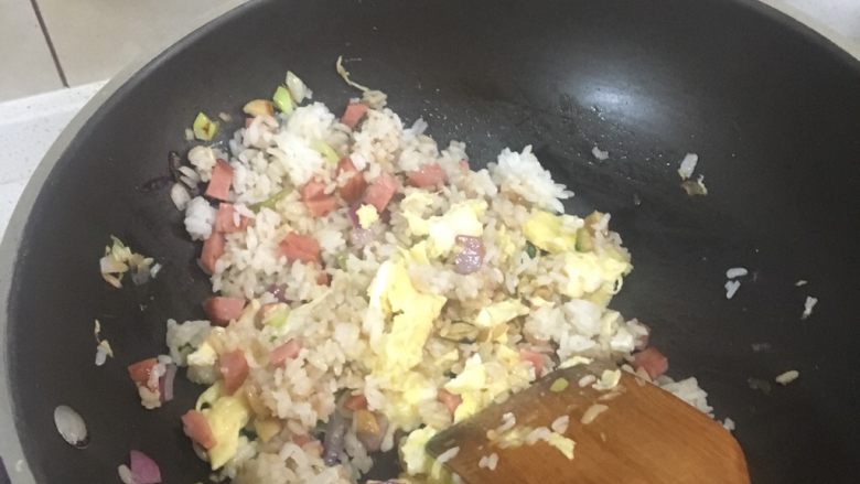 炒饭秀家常炒饭,加入最开始炒好的鸡蛋。最后加入小半勺食盐再小炒一会,看到米饭颗粒分明时,准备出锅。