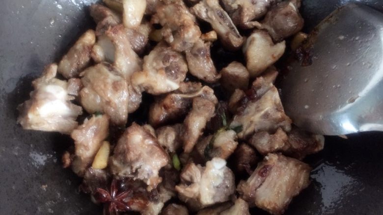 板栗烧排骨,迅速倒入排骨和香料翻炒,让每一块排骨都均匀的裹上糖色。