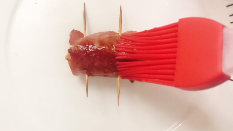 鞭炮齐鸣,用刷子蘸取蚝油酱汁,刷在培根卷上。