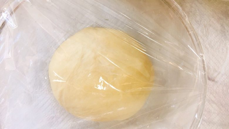 金黄诱人的椰蓉扭扭条面包,取出面团揉圆,盖上保鲜膜室温发酵一小时。
