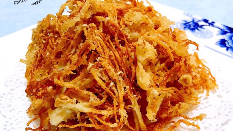 酥炸金针菇,炸至好的金针菇摆入盘中