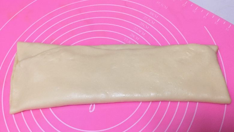 早餐+奶香椰蓉棒,从长的一端开始向中间位置对折,再对折,折成一个长方形。