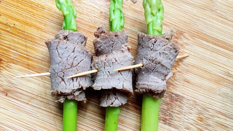 凉拌芦笋牛肉卷,裹好芦笋用牙签固定住。