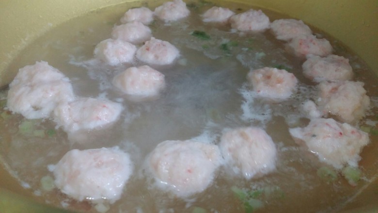 虾丸菠菜汤,把腌制好的虾泥挤出丸子。在虎口处挤出丸子,用勺子挖下来放入锅中。