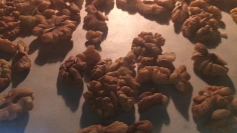 金秋玫瑰五仁月饼,核桃仁如果不是熟的,就放入烤箱烤熟,烤到核桃皮看着有一点冒油就可以了 再烤就过火了