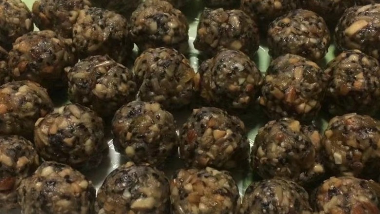 金秋玫瑰五仁月饼,拌好的五仁馅放入盆子里盖上保鲜膜放置半小时以上,不出油就证明馅做的非常成功,然后按照比例称重35g一个,一共41个五仁馅搓圆,戴上一次性手套不粘手