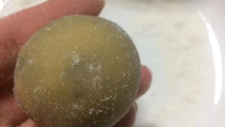 金秋玫瑰五仁月饼,捏成鸡蛋状,放入熟糕粉中裹少许粉面