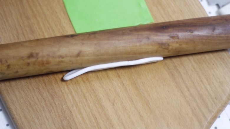 零基础纸杯翻糖蛋糕,用擀面杖竖着压一下白色糖皮棍,压就好,不用擀。