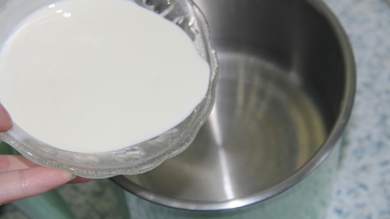巧克力牛奶双色布丁,奶锅里面倒入淡奶油,倒入一半