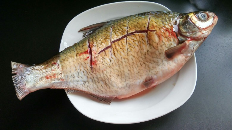 豆瓣酱烧鳊鱼,将<a style='color:red;display:inline-block;' href='/shicai/ 390'>鳊鱼</a>洗净,用刀在鱼背划十字,抹适量的盐腌制两小时入味