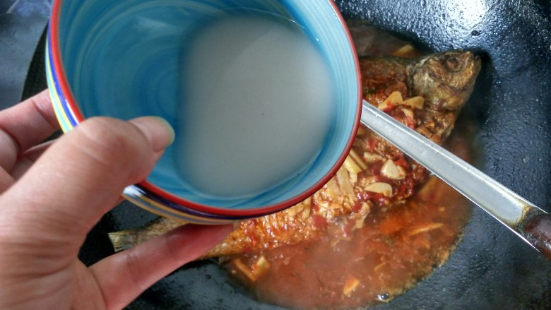 豆瓣酱烧鳊鱼,锅中的汤汁变得浓稠,鱼已经烧熟,倒入调好的淀粉汁