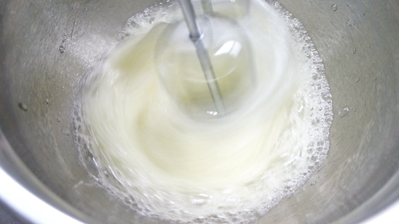 韩式豆沙裱花戚风蛋糕,60克白糖分三次放入蛋白糊中,第一次,用电动打蛋器中速将蛋清打出粗泡;