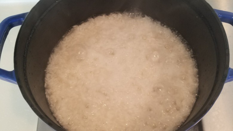 广式腊味煲仔饭,将锅移至火上,中火煮开后立即转为小火。