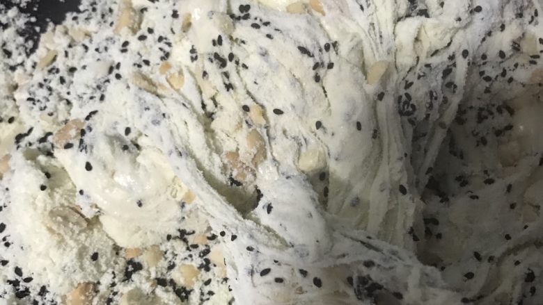 手工花生牛轧糖,放入奶粉和黑芝麻 花生碎搅拌均匀,关火