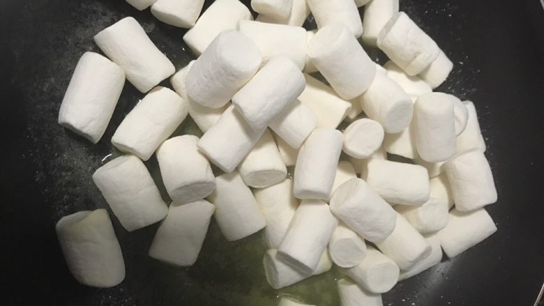 手工花生牛轧糖,黄油完全融化后放棉花糖,小火上下翻拌 等棉花糖和黄油完全均匀融合在一起