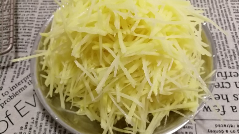 酥香三丝,洗好的土豆丝装盘里,准备用油炸。
