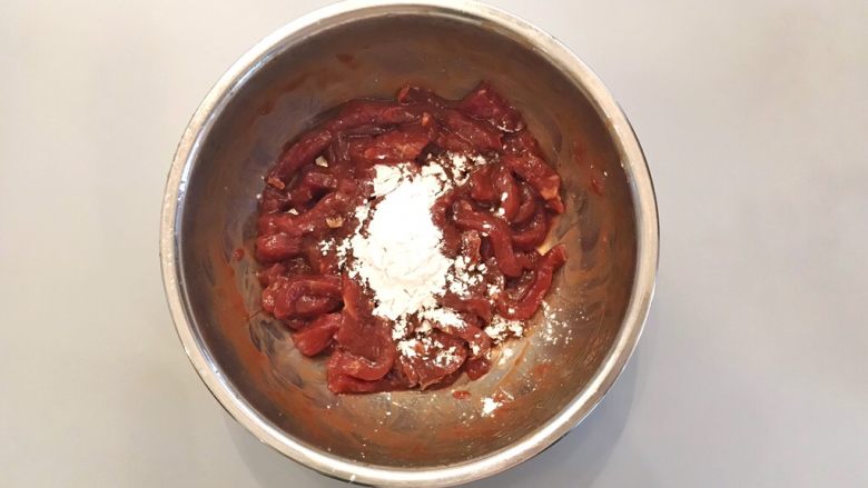 孜然牙签牛肉,腌制完成后,可以看到碗底的水已经完全被肉吸收了,然后加入10g淀粉,搅拌均匀;