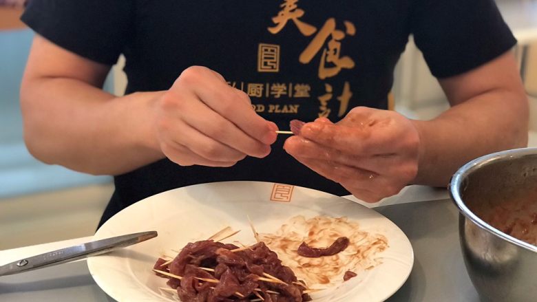 孜然牙签牛肉,接下来就是穿肉啦,用牙签将切好的条状肉一根根穿好,此步骤需要有耐心哦;
