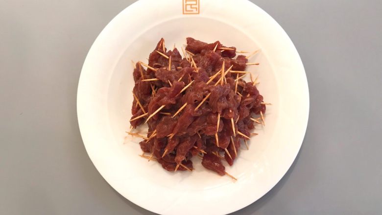 孜然牙签牛肉,所有牙签肉穿好,置于盘中;
