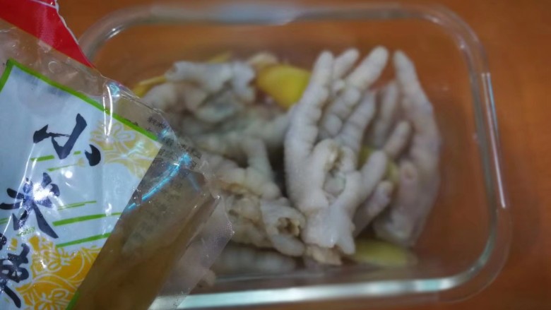 柠香泡椒凤爪,浸泡好的鸡爪放入玻璃保鲜盒,加入一袋泡水小米料,连同泡椒水一起倒入。