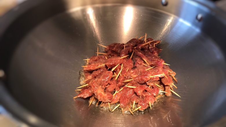 孜然牙签牛肉,牙签肉下锅,先不着急翻动,待闻到肉香味,底部的肉成熟时在翻炒;