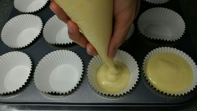 纸杯蛋糕cupcake,裱花袋挤入蛋糕托,每个装八分满