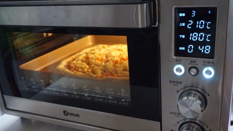 玉米培根披萨,放入已经提前预热上火210度,下火180度的东菱K40C烤箱下层,烘烤15分钟左右