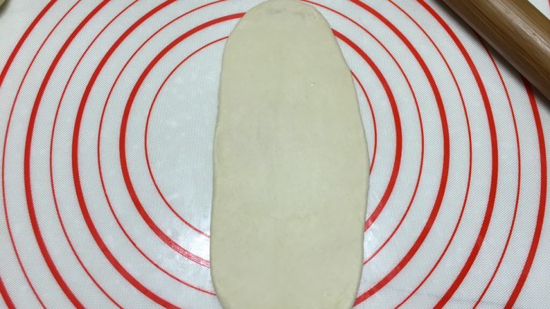 芝士培根面包(波兰种),取一个面团,用擀面杖擀成舌形