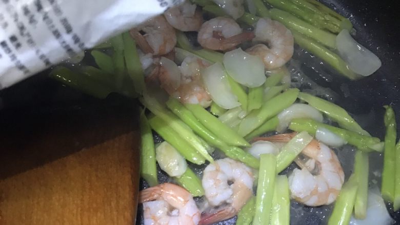 绿色美食芦笋百合炒虾仁,翻炒至变色,加入少许盐调味
