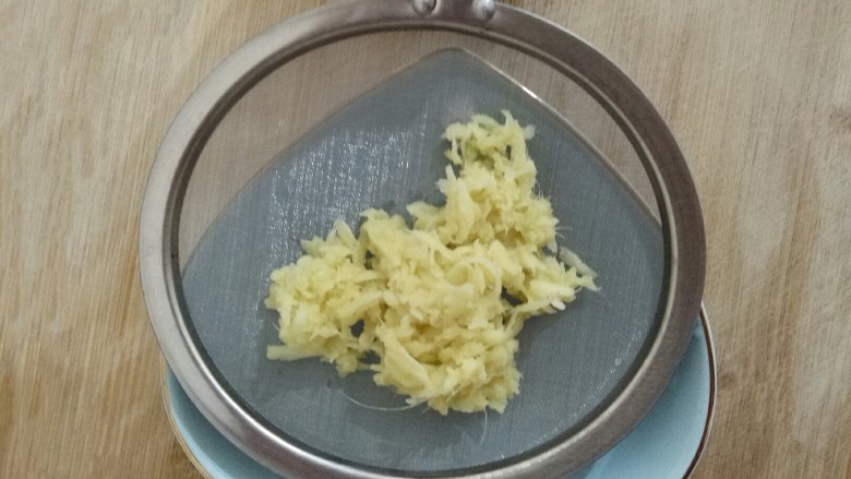 姜撞奶,倒入部分姜泥,用勺子按压