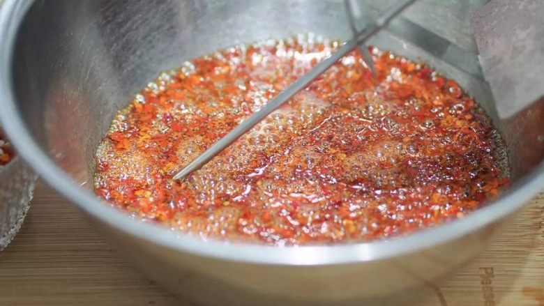 夏至面,继续观察温度计,
待油温下降到130左右的时候,
倒入装有纯辣椒面的碗里。