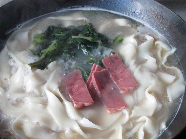牛骨汤烩面,面煮熟后加入牛肉和<a style='color:red;display:inline-block;' href='/shicai/ 3517'>青菜</a>,稍煮1分钟即可出锅