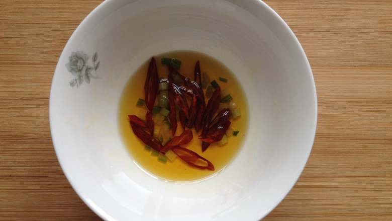 蓑衣黄瓜,将热油淋入辣椒和葱花上炸出香味(油没用完,不用太多)