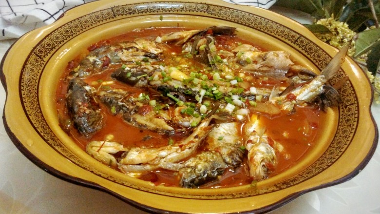 香辣鲫鱼,将鱼出锅装盘,将小香葱花洒在鱼身上。好啦,可以美美的吃啦!