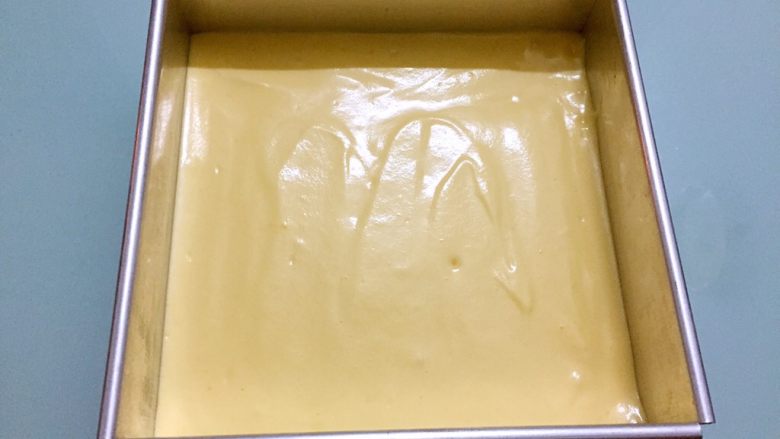 戚风蛋糕,烤箱上火90度,下火120度预热,将蛋糕糊倒入八寸模具中,拿刮刀抹平表面,用手端住模具用力震几下,把大气泡震掉。