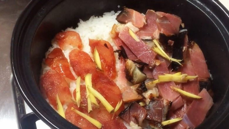 腊味双拼煲仔饭,铺上腊肉腊肠姜丝继续煮5~8分钟