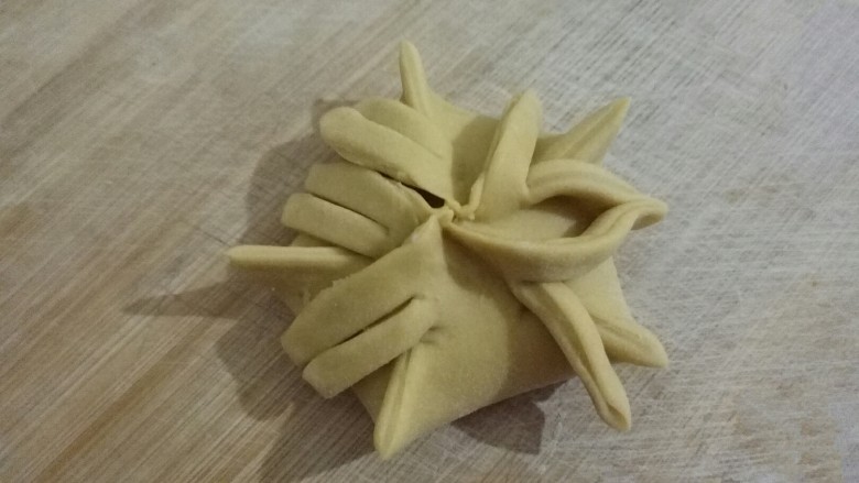 兰花蒸饺,5个折都剪好,第1个折的第1条和第2个折的第2条对着捏拢