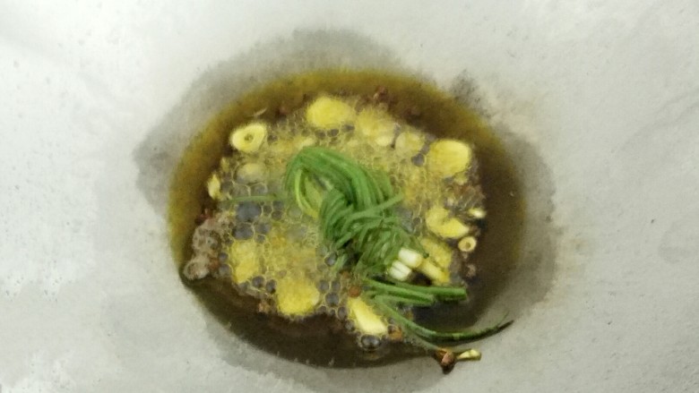 凉拌莴笋,锅里放入适量油烧热后,放入花椒、蒜、香葱结,煸出香味,即可关火