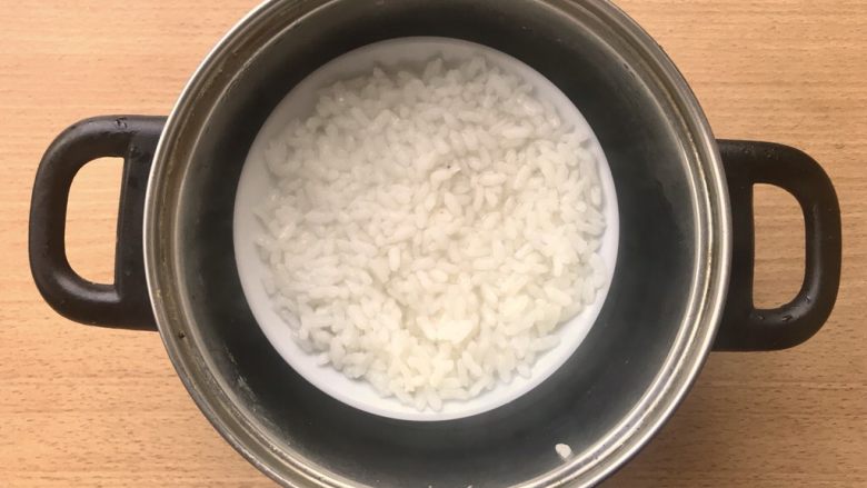晚餐+一碗芝士排骨饭,稍微休息一下就可以将腌制米的碗放入差不多到碗一半的开水,整个锅在灶上煮10分钟。就会有大致如图水收干快熟的一碗米饭。
