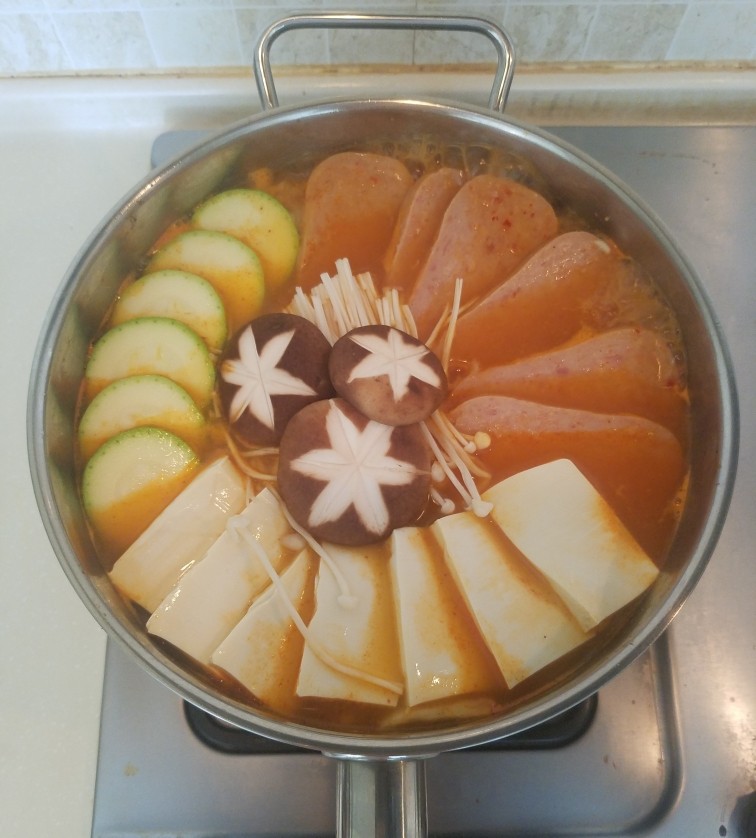 泡菜锅,再把午餐肉,豆腐,西葫芦,香菇和金针菇码好,盖上锅盖改成中火咕嘟几分钟。