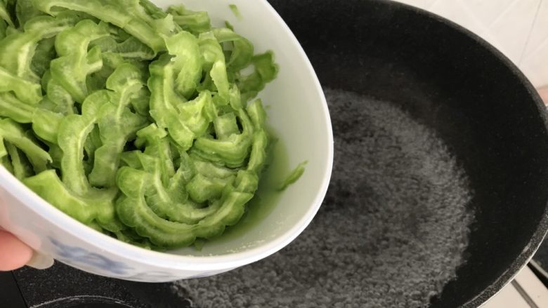 绿色美食~苦瓜炒蛋,锅里烧开水后,苦瓜倒入灼水,去除草酸,不要太久,变色即捞起