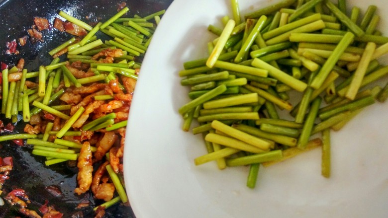 绿色美食+蒜苔炒肉丝,倒入蒜苔,继续翻炒。